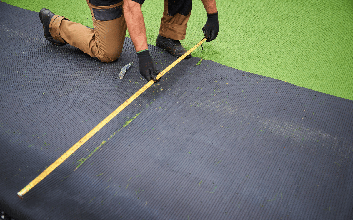 Profesional fijando césped artificial para garantizar una instalación perfecta